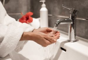 a woman using the bathroom faucet