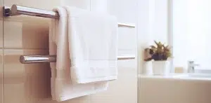 A white towel hanging on a stainless towel holder
